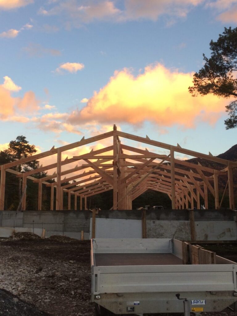 Beau coucher de soleil sur la construction d'un hangar agricole en bois à la ferme du Lauzon