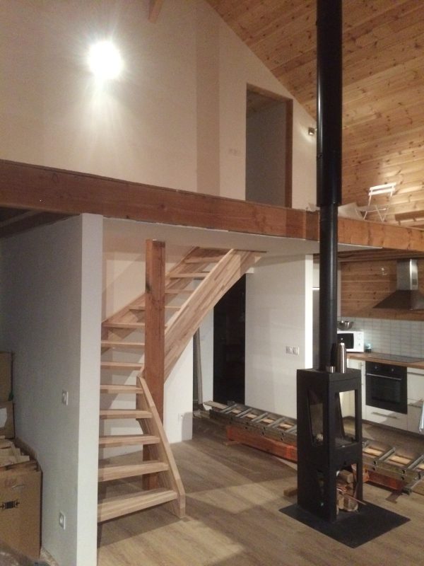 Intérieur d'une maison ossature bois avec un bel escalier en hêtre sur mezzanine