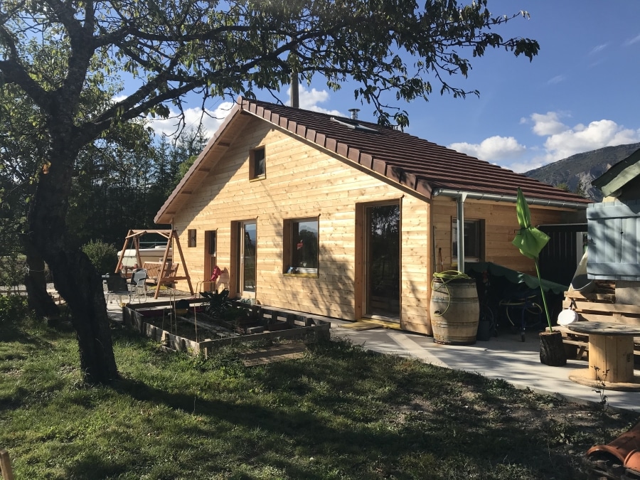 Maison en dur isolée par l'extérieur en fibre de bois et bardée en mélèze