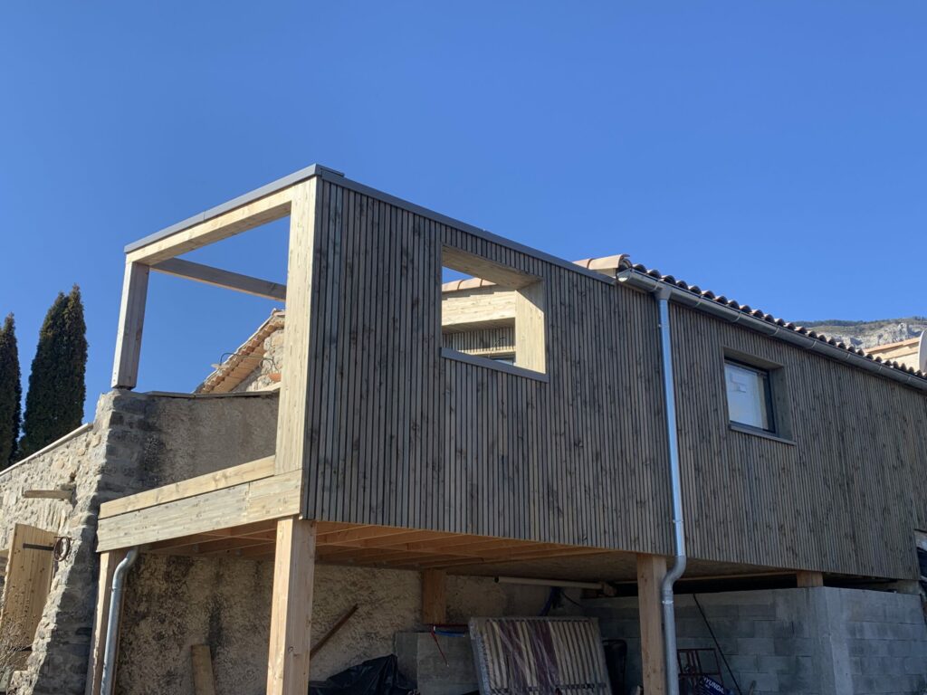 Extension en ossature bois bardé en clair voie douglas imprégnation gris