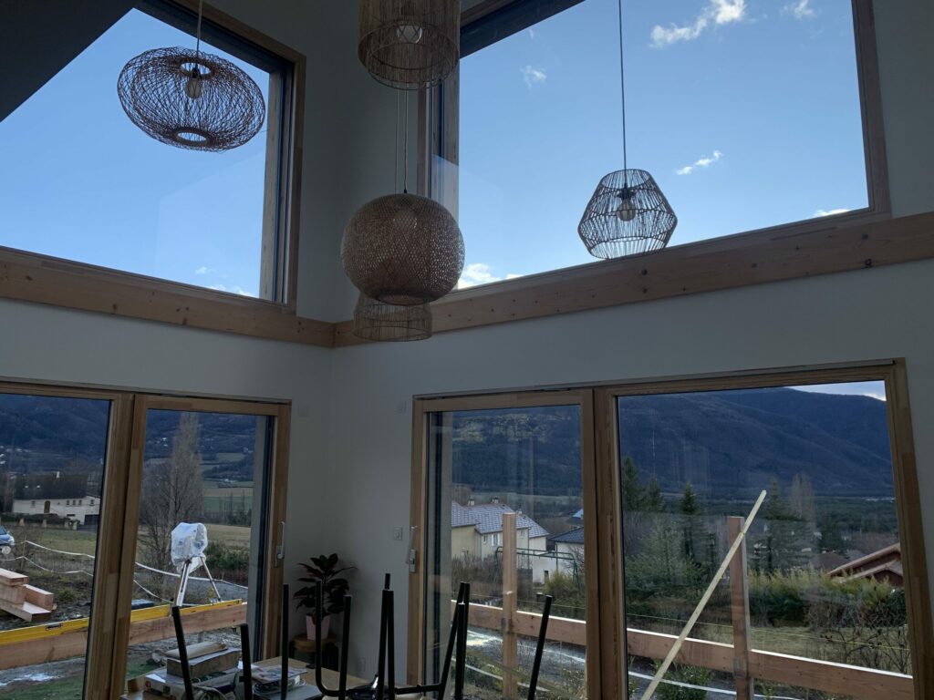 Intérieur d'une maison en ossature bois bardage en douglas, mélange de crépis - Abri voiture en douglas - Terrasse en douglas - Intradosse Hautes-Alpes