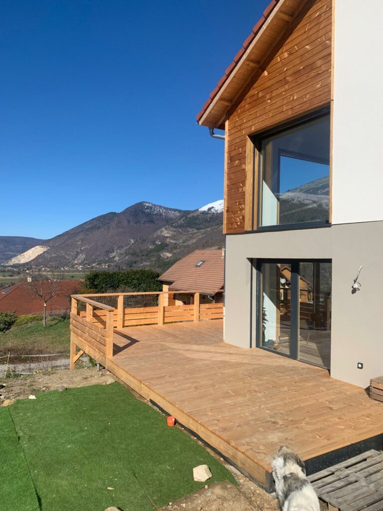 Maison en ossature bois bardage en douglas, mélange de crépis - Abri voiture en douglas - Terrasse en douglas - Intradosse Hautes-Alpes